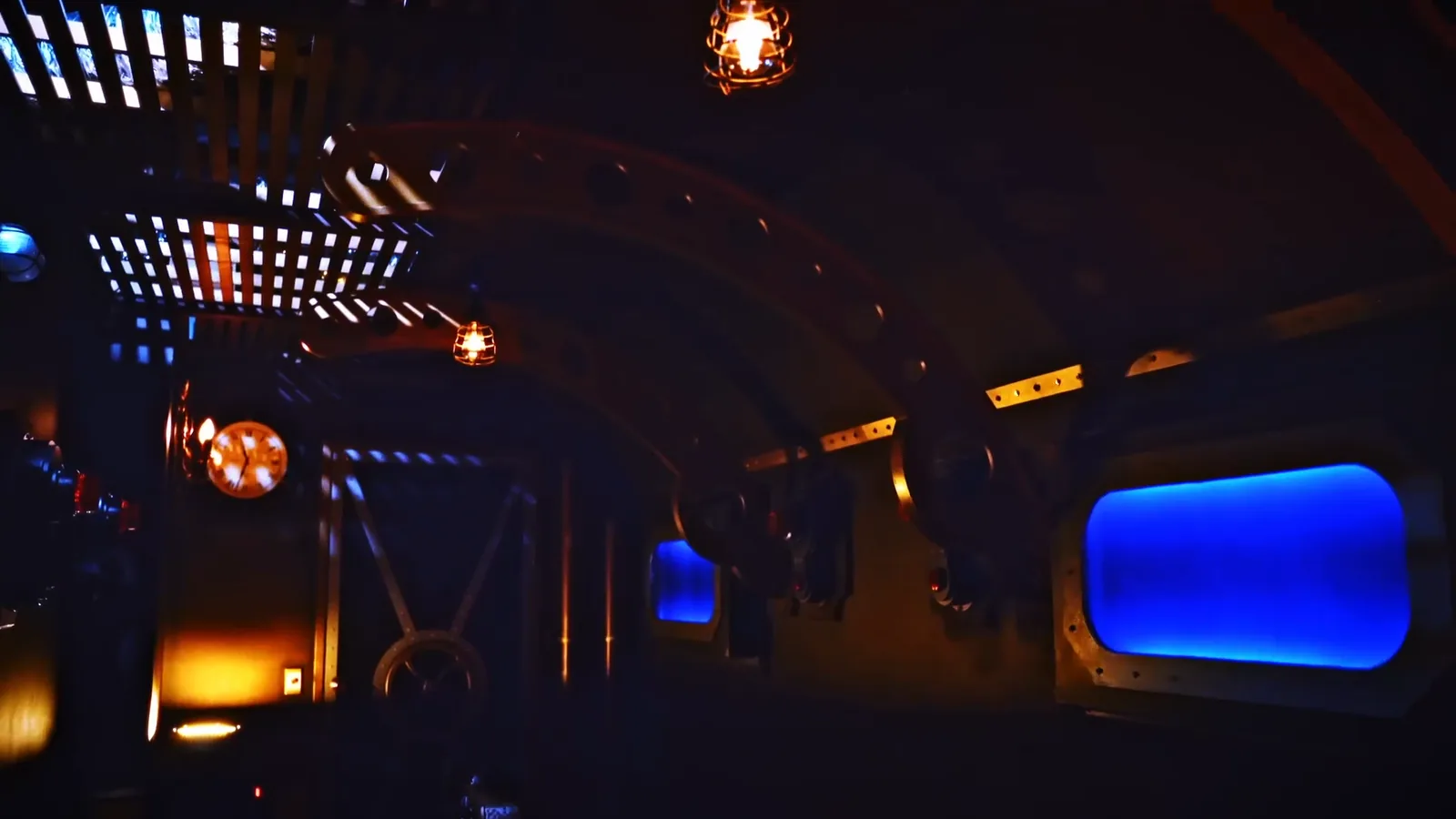 The riveted brass corridor of the Nautilus, lit by caged lamps
